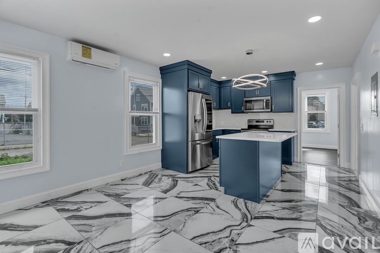 A modern kitchen with a blue cabinet and marble flooring.