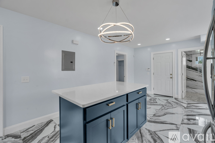 A kitchen with a white countertop and blue cabinets.