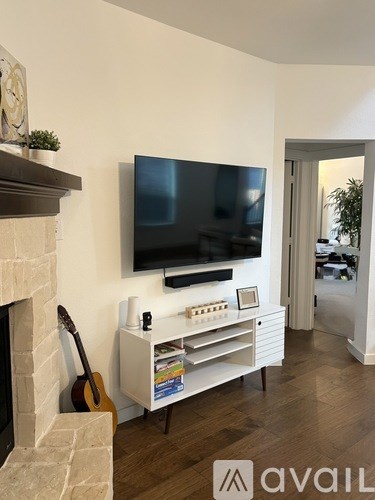 A living room with a television and a fireplace.