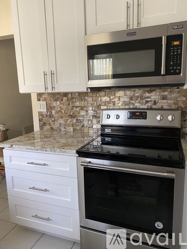 A kitchen with a stove top oven and microwave above it.