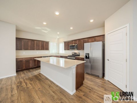 A kitchen with wooden cabinets and a white island.