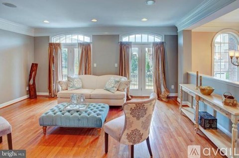 A living room with a wooden chair and a framed picture on the wall.