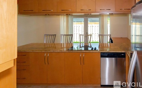 A kitchen with wooden cabinets and a stainless steel dishwasher.