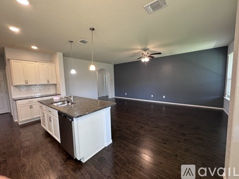 A kitchen with white cabinets and a black countertop.