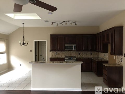 A kitchen with brown cabinets and a white island.