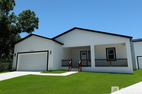 A white house with a black roof and a garage door.
