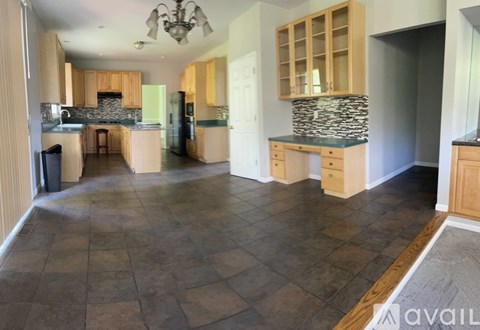 A kitchen with tile flooring and wooden cabinets.