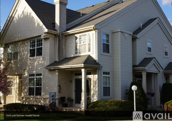 A large, well-maintained house with a front porch and multiple windows.