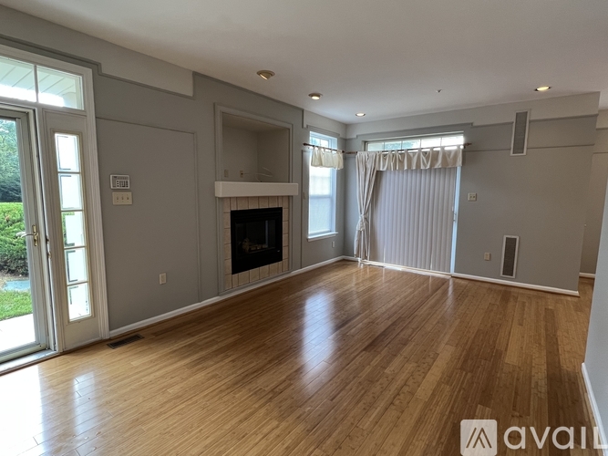 A spacious living room with a fireplace and hardwood floors.