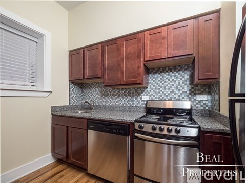 A kitchen with brown cabinets and a stainless steel dishwasher and oven.