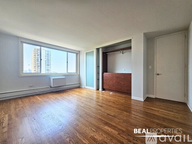 A kitchen with a refrigerator, cabinets, and a window.