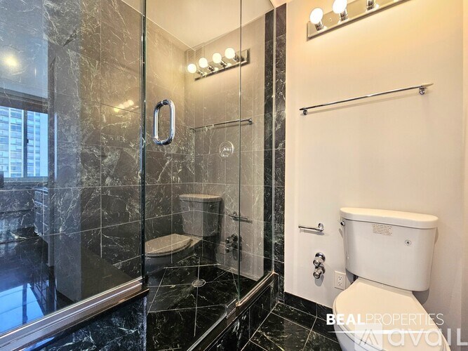 A bathroom with a toilet, sink, and mirror.