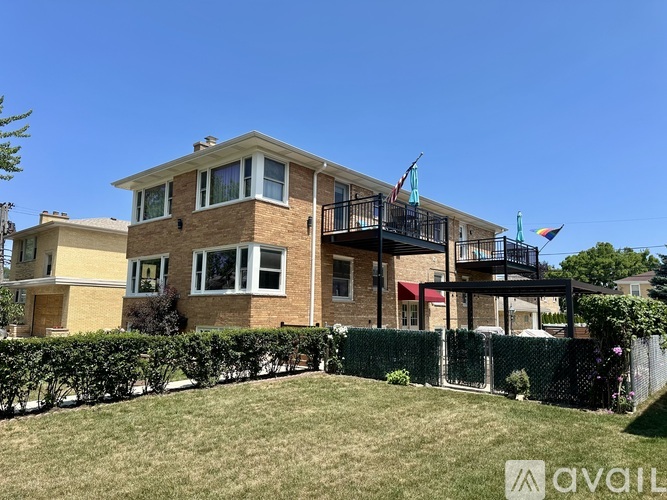 A two-story brick house with a balcony on the second floor.