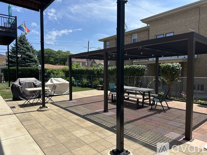 A balcony with a table and chairs is attached to a brick building.