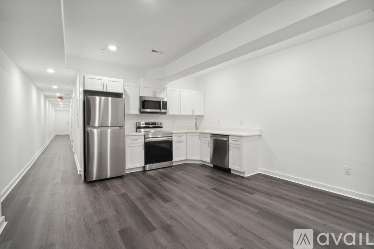 A kitchen with white cabinets and a stainless steel refrigerator.