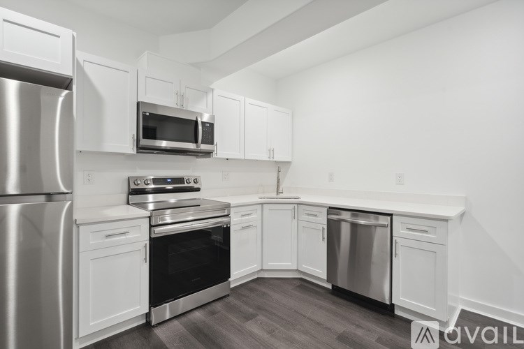 A modern kitchen with white cabinets and stainless steel appliances.