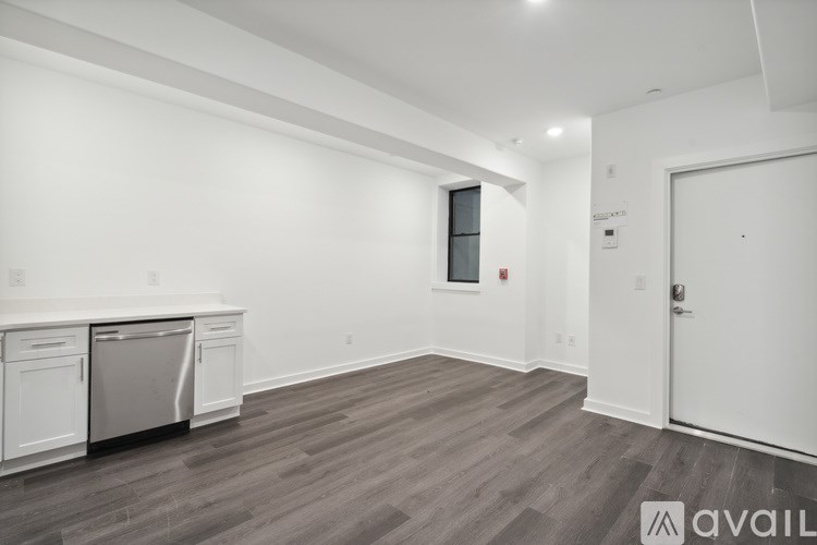 A kitchen with white cabinets and a dishwasher is available.