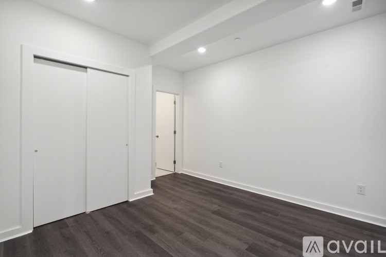 A room with a white wall and a wooden floor.