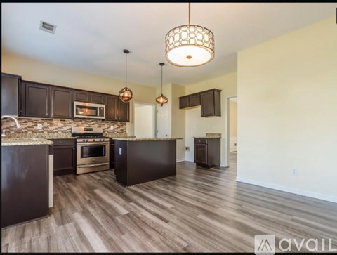 A kitchen with dark brown cabinets and a stainless steel oven.