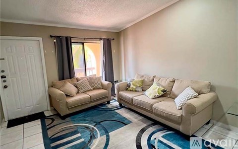 A living room with two couches and a rug.