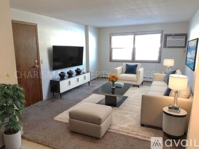 A living room with a flat screen TV, a white sofa, and a coffee table.
