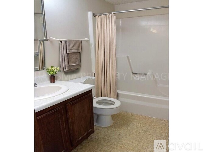 A bathroom with a toilet, sink, and shower curtain.