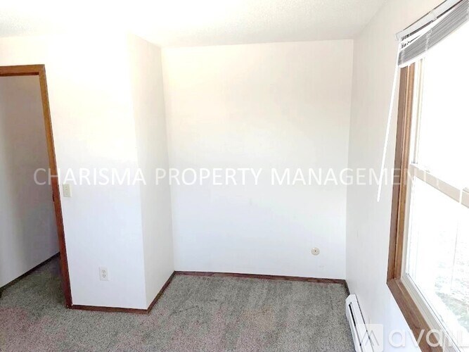 A room with a window and a door, managed by Charisma Property Management.
