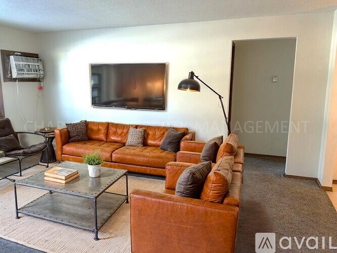 A living room with a brown leather couch and a glass coffee table.