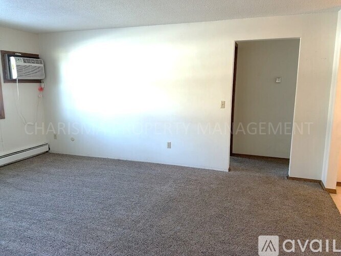 A sparsely furnished room with a door and a window.