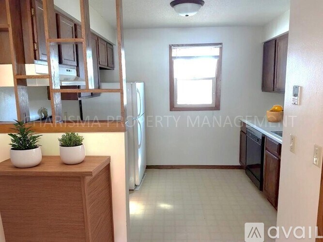 A kitchen with wooden cabinets and a refrigerator.
