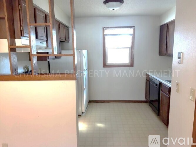 A kitchen with white appliances and wooden cabinets.