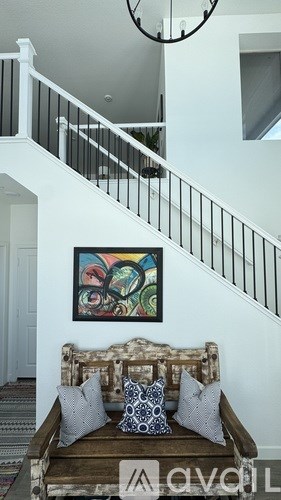 A living room with a couch and a painting on the wall.