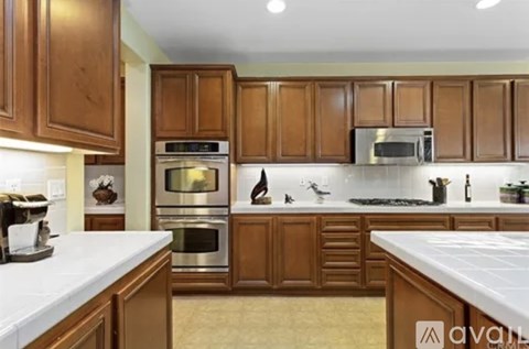 A kitchen with wooden cabinets and a white countertop.