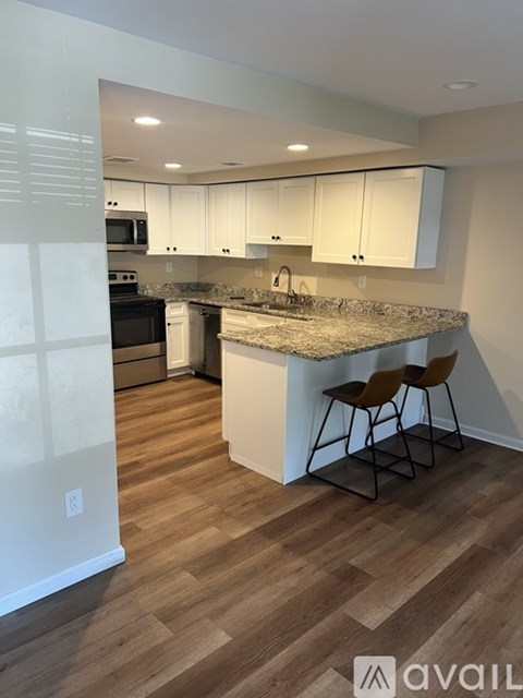 A kitchen with a granite countertop and wooden flooring.