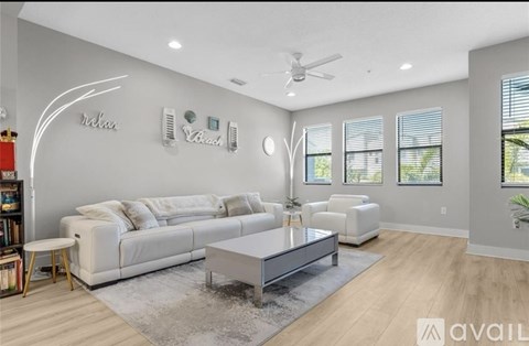 A living room with a white sofa and a glass coffee table.