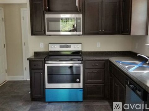 A kitchen with a blue oven and black cabinets.