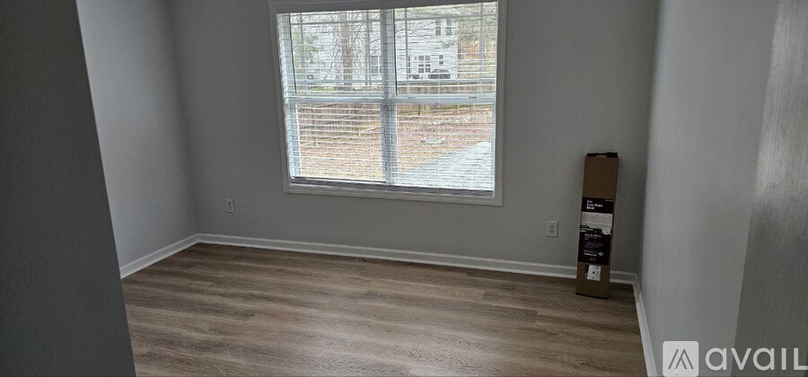 A room with a window and wooden flooring.