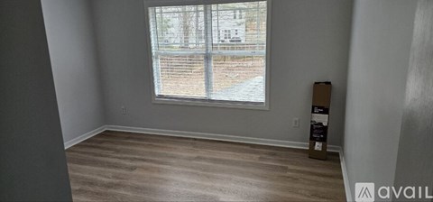 A room with a window and wooden flooring.