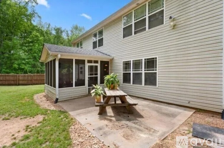 A house with a covered patio and a picnic table.