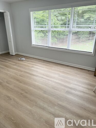 A room with a window and wooden flooring.