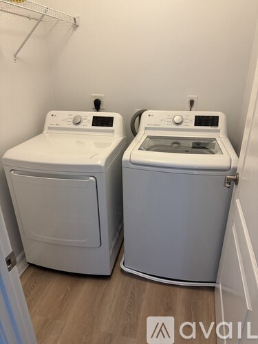 Two front loading washing machines in a small laundry room.