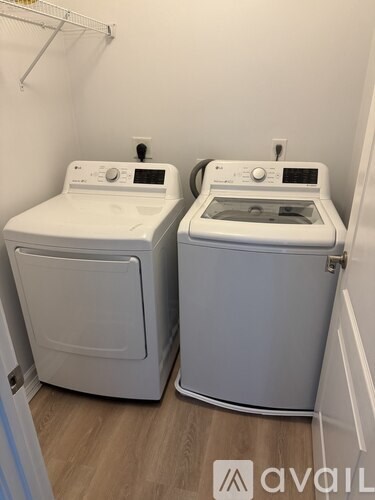 Two front loading washing machines in a small laundry room.