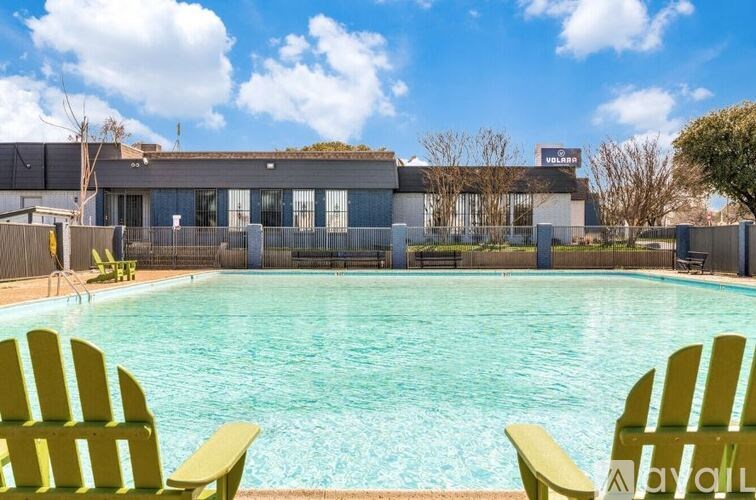 Two yellow chairs are placed in front of a swimming pool.