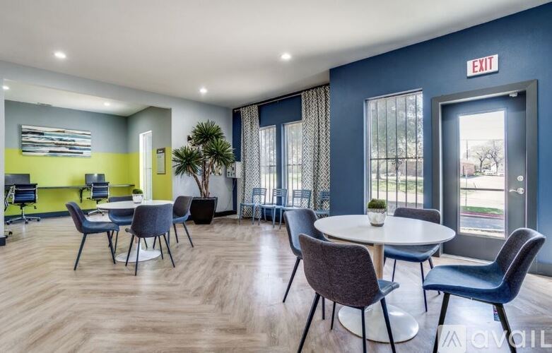 A room with a round table and chairs with a sign that says "EXIT" on the wall.