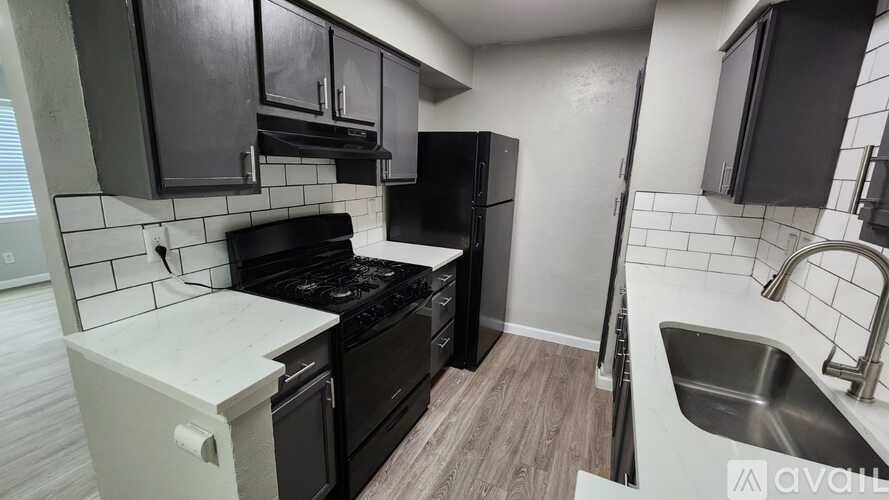 A kitchen with black cabinets and a white countertop.