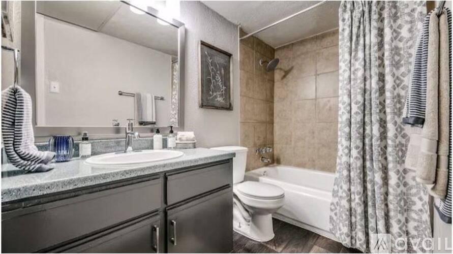 A bathroom with a toilet, sink, and shower.