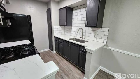 A kitchen with black cabinets and a white countertop.