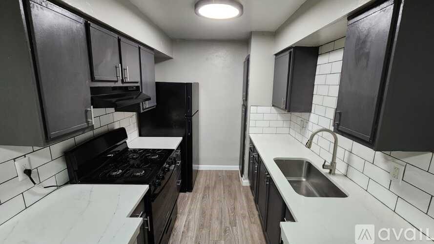 A kitchen with black cabinets and a white countertop.