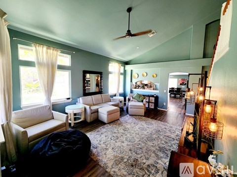 A living room with a white couch and a rug.