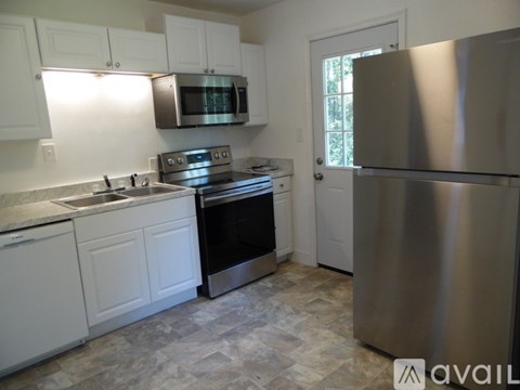 A kitchen with white cabinets and a stainless steel refrigerator.
